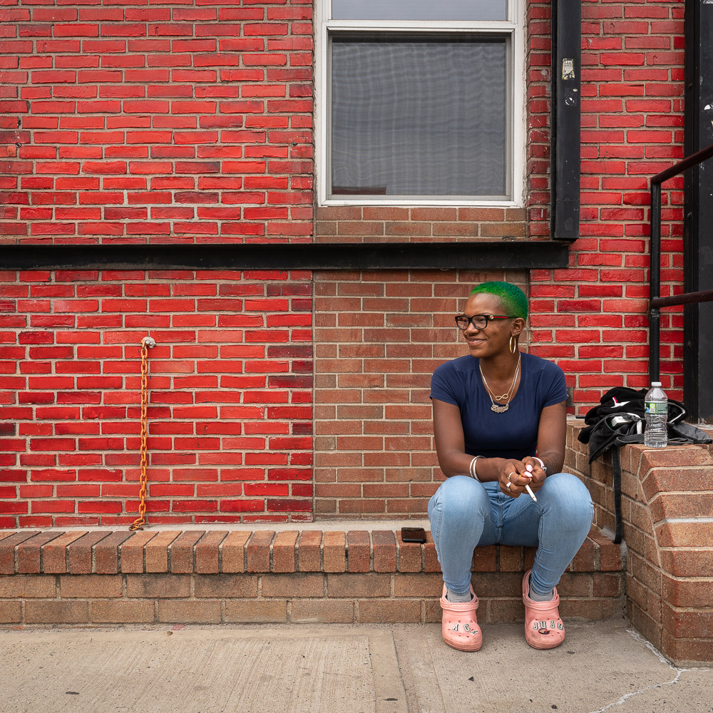 Photo: Woman sitting on a stoop in Brooklyn