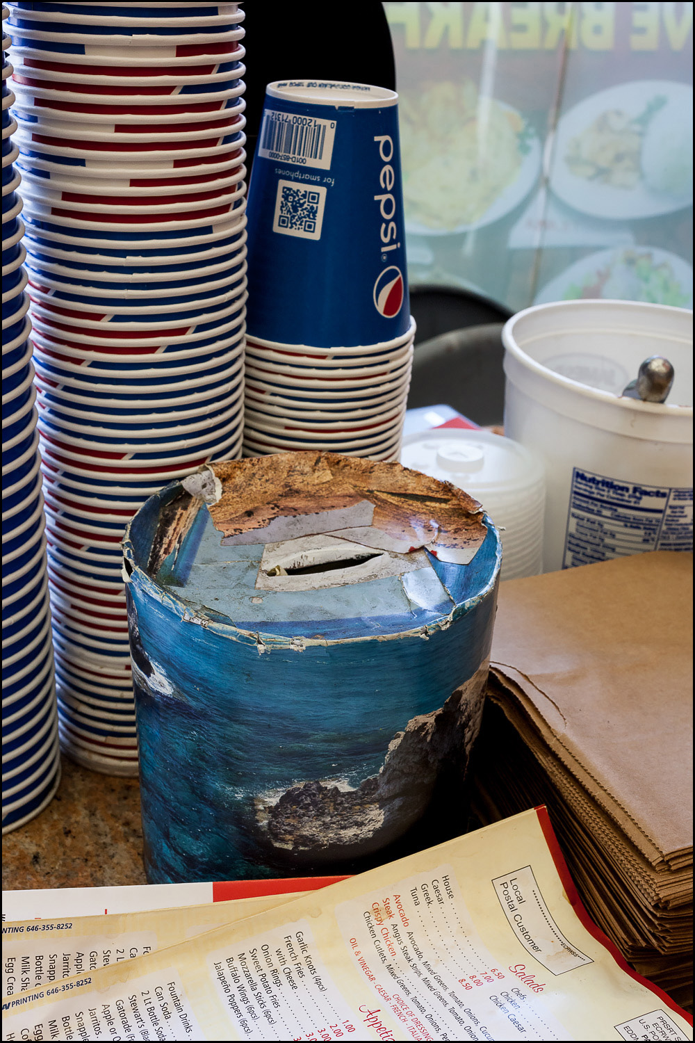 Photograph: collage cardboard tube used as a tip jar.